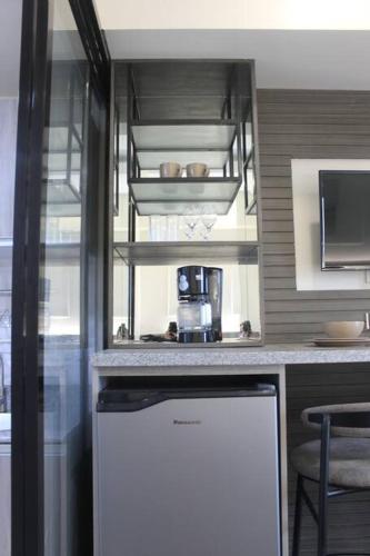 a kitchen with a white refrigerator and a counter at Condo near Ayala Cebu City w Wifi Balcony in Cebu City