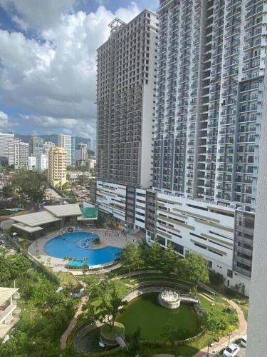 a large building with a swimming pool in front of it at Condo near Ayala Cebu City w Wifi Balcony in Cebu City