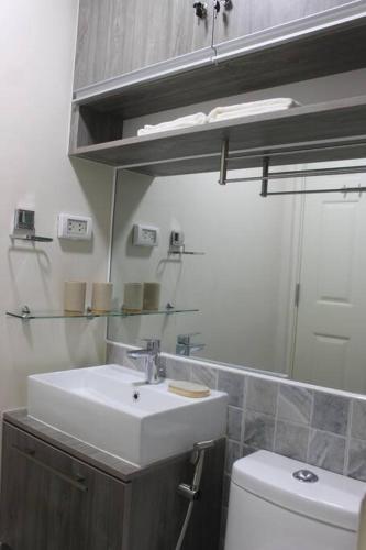 a bathroom with a sink and a toilet at Condo near Ayala Cebu City w Wifi Balcony in Cebu City