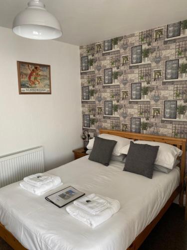 a bedroom with a bed with towels on it at Willow Dene in Scarborough