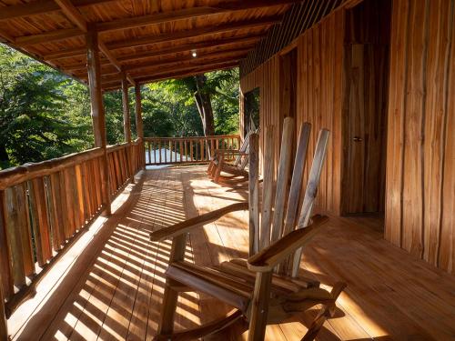 two rocking chairs sitting on the porch of a cabin at Finca Colibri Ecolodges en Pleine Nature ferry Playa Najanjo Costa Rica in Cabo Blanco