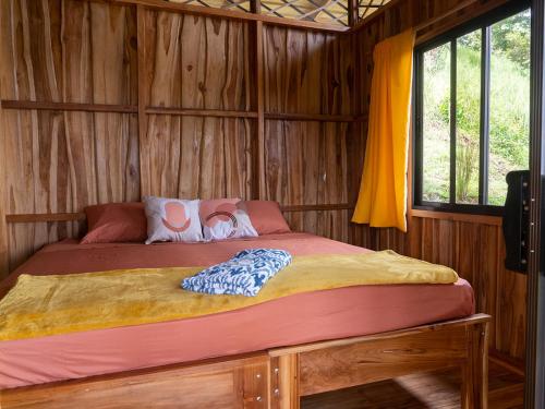 1 dormitorio con 1 cama en una cabaña de madera en Finca Colibri écolodges en nature Costa Rica, en Cabo Blanco