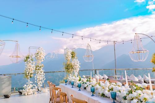 a table with white flowers and chandeliers at Sapa Relax Hotel & Spa in Sa Pa