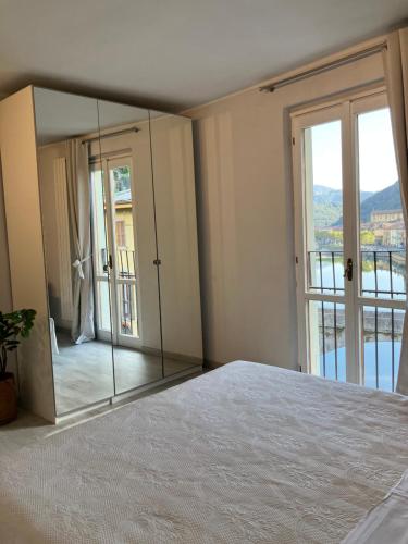 1 dormitorio con espejo grande junto a la cama en Al ponte vecchio, en San Pellegrino Terme