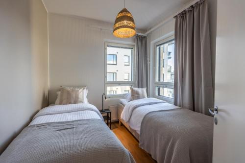 two beds in a room with a window at Quality Suite with Sauna - 2 Bedrooms - BRAND NEW 2022 in Rovaniemi