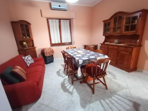 ein Wohnzimmer mit einem Tisch und einem roten Sofa in der Unterkunft Fontana Nuova in Sardara