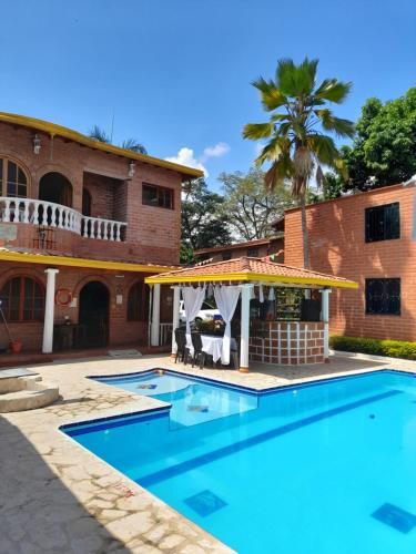 a swimming pool in front of a house at Hotel Boutique Los Gentiles in Santa Fe de Antioquia