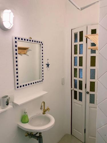 a bathroom with a sink and a mirror at Apartamento Color Centro Histórico - Vila Ilhabela in Ilhabela