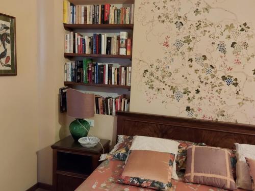 ein Schlafzimmer mit einem Bett und einem Bücherregal mit Büchern in der Unterkunft Villa di Elisabeth in Marciano Della Chiana