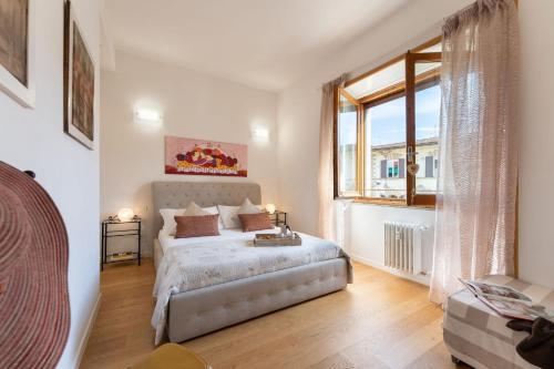 a bedroom with a bed and a large window at Santa Maria Novella - Flo Apartments in Florence