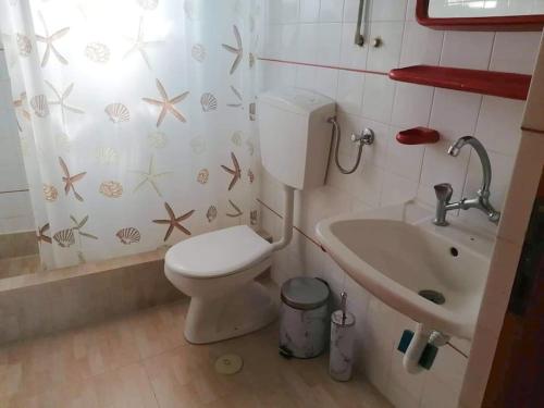a bathroom with a toilet and a sink at Angela's place - Stomio residence near the sea in Stómion