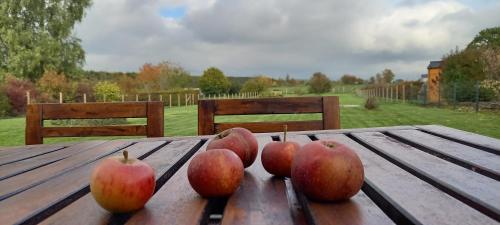a group of apples sitting on a wooden table at Gite A bicyclette in Dinez