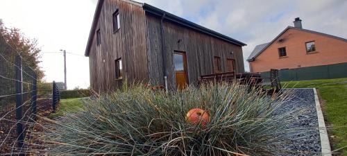 an old wooden barn with a bench in front of it at Gite A bicyclette in Dinez