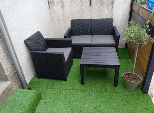 a patio with two chairs and a table on grass at • CosyHouse By Janna • Terrasse - Wifi in Châtellerault