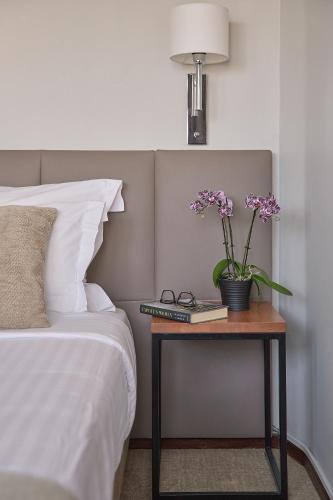 a bedroom with a bed and a table with flowers on it at Hotel Dom Carlos Park in Lisbon