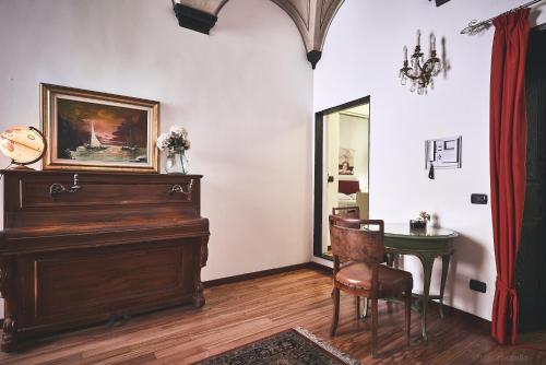 a room with a piano and a table and a mirror at Affittacamere San Teodoro in Albenga