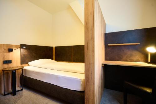 a hotel room with a bed and a desk at Wallner - Hotel & Wirt in Arnoldstein