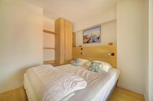 - une petite chambre avec un lit blanc et 2 oreillers dans l'établissement GHD4 - 2 pièces, Résidences du Grand Hôtel, à Cannes