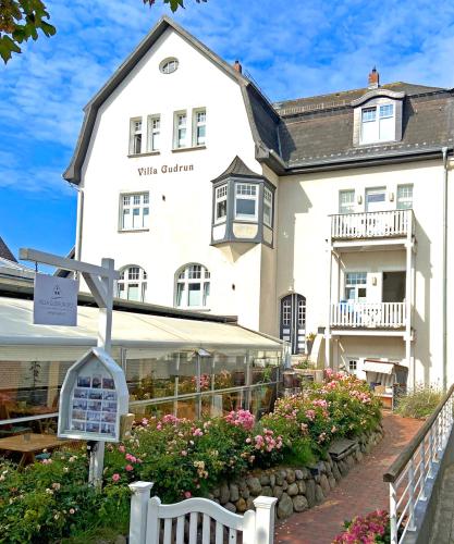 a white building with a sign in front of it at Villa Gudrun in Westerland