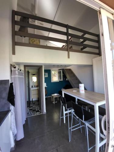 une pièce avec une table, des chaises et un escalier dans l'établissement MINI VILLA A 5MIN À PIEDS DE LA PLAGE SANTA GIULIA, à Porto-Vecchio