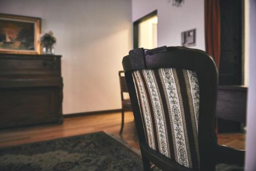 a black chair sitting in a room with a piano at Affittacamere San Teodoro in Albenga
