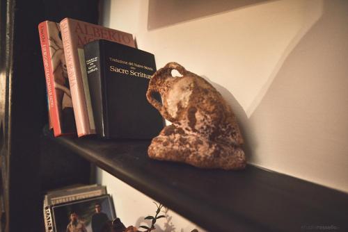 a shelf with books and a rock on it at Affittacamere San Teodoro in Albenga