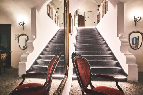 a staircase with two chairs and a mirror at Affittacamere San Teodoro in Albenga
