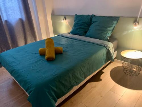 a bed with a teddy bear sitting on top of it at Spacieux Appartement Lumineux Cœur De Ville in Pamiers