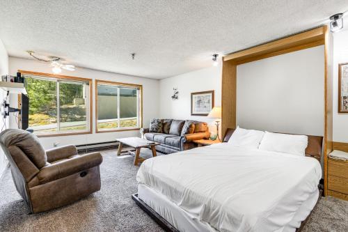 a bedroom with a bed and a couch and a chair at Snowblaze Condominiums E103 in Winter Park