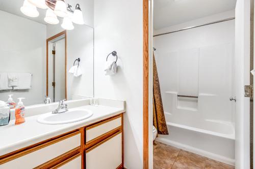 ein Badezimmer mit einem Waschbecken, einer Badewanne und einer Dusche in der Unterkunft Snowblaze Condominiums E103 in Winter Park