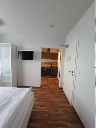 a white room with a bed and a kitchen at Haus Achtern Diek in erster Reihe am Meer in Fehmarn
