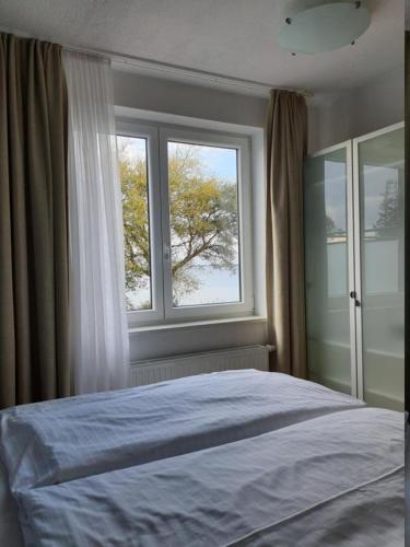 a bedroom with a large bed and a window at Haus Achtern Diek in erster Reihe am Meer in Fehmarn