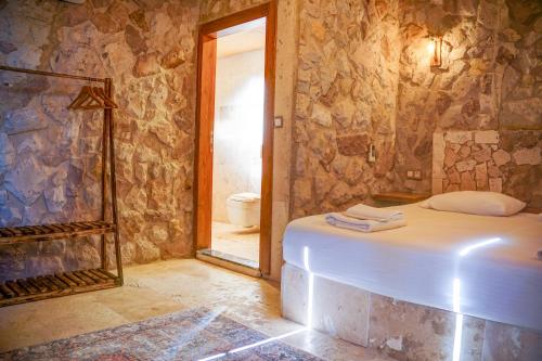 a room with a bed and a bathroom with a shower at Ala Stone House in Goreme