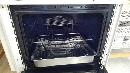 an oven is open with a pans in it at CASA GORDON in Navaluenga