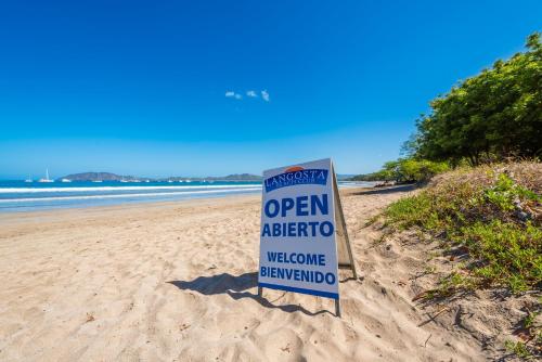 a sign in the sand on a beach at Jet Luxury at Langosta Beach Resort & Villas in Tamarindo