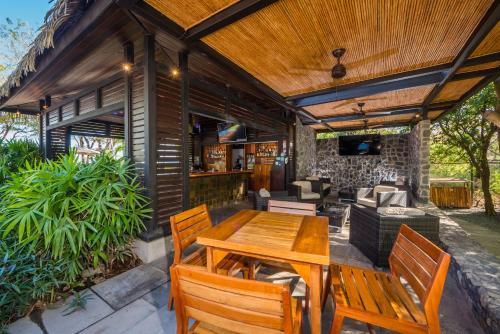 an outdoor patio with a wooden table and chairs at Jet Luxury at Langosta Beach Resort & Villas in Tamarindo