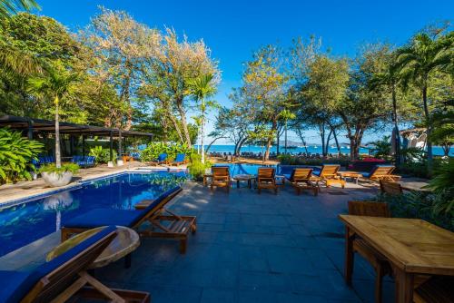 a resort with a pool and tables and chairs at Jet Luxury at Langosta Beach Resort & Villas in Tamarindo