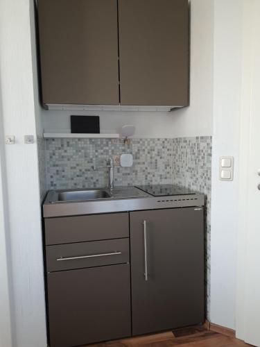 a small kitchen with a sink and a cabinet at Haus Achtern Diek in erster Reihe am Meer in Fehmarn