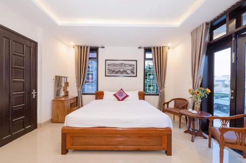 a bedroom with a bed and a table and chairs at Papaya Garden Homestay in Hoi An