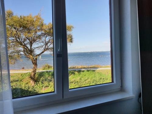 an open window with a view of the ocean at Haus Achtern Diek in erster Reihe am Meer in Fehmarn