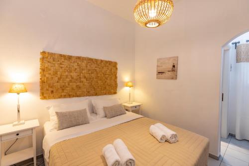 a bedroom with a large bed with towels on it at Irini pension in Platis Yialos Sifnos