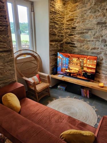 a living room with a couch and a tv at Villa Alva Guest House in Coja