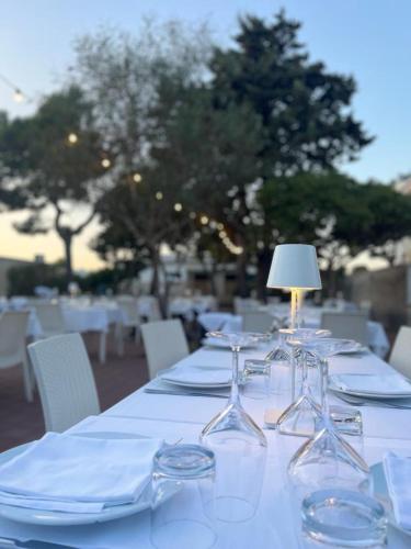 a table with plates and wine glasses on it at Casa Mita in Pulsano