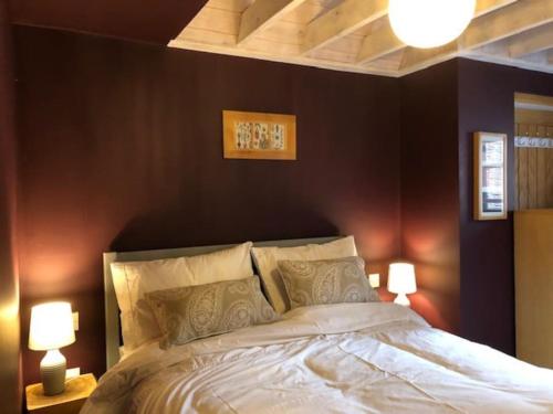 a bedroom with a large bed with two lamps at Bank Studio - luxury Cotswolds haven for two in Shipston-on-Stour