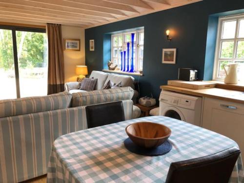 a living room with a couch and a table with a bowl on it at Bank Studio - luxury Cotswolds haven for two in Shipston-on-Stour