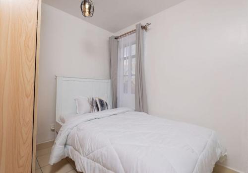 Athi River的住宿－Athi Luxury Suites，卧室配有白色的床和窗户。