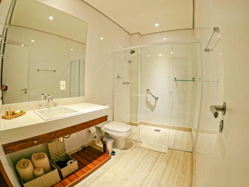 a bathroom with a shower and a sink and a toilet at Austin Suites in Campos do Jordão
