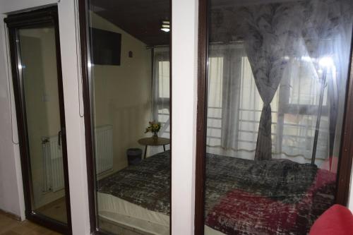 a bedroom with a bed and a window with a mirror at Camere Centrale in Piteşti