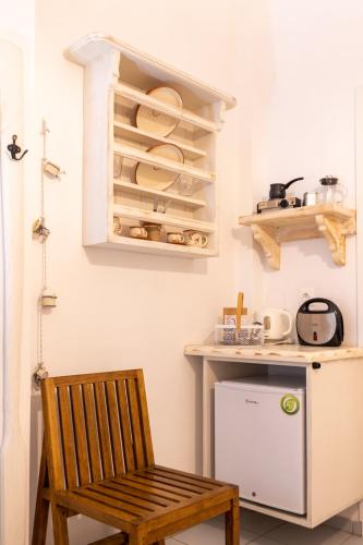 a kitchen with a wooden chair and a refrigerator at Irini pension in Platis Yialos Sifnos