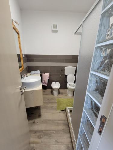 a bathroom with a toilet and a sink at Baia Palmeira Residence in Palmeira